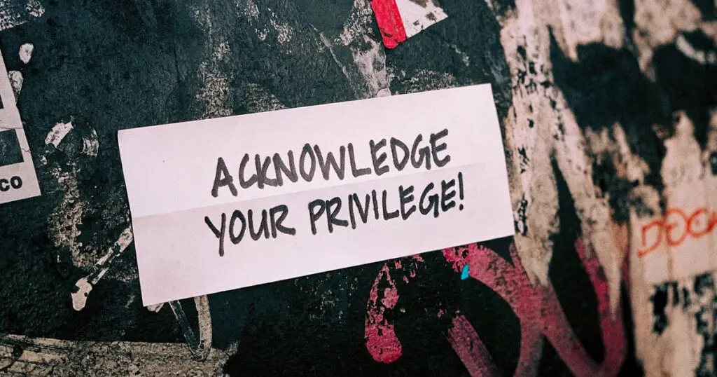 Acknowledge Your Privilege sign on a messy wall