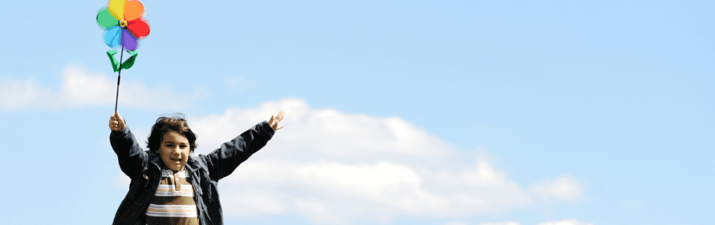 A child holding a pinwheel in the air