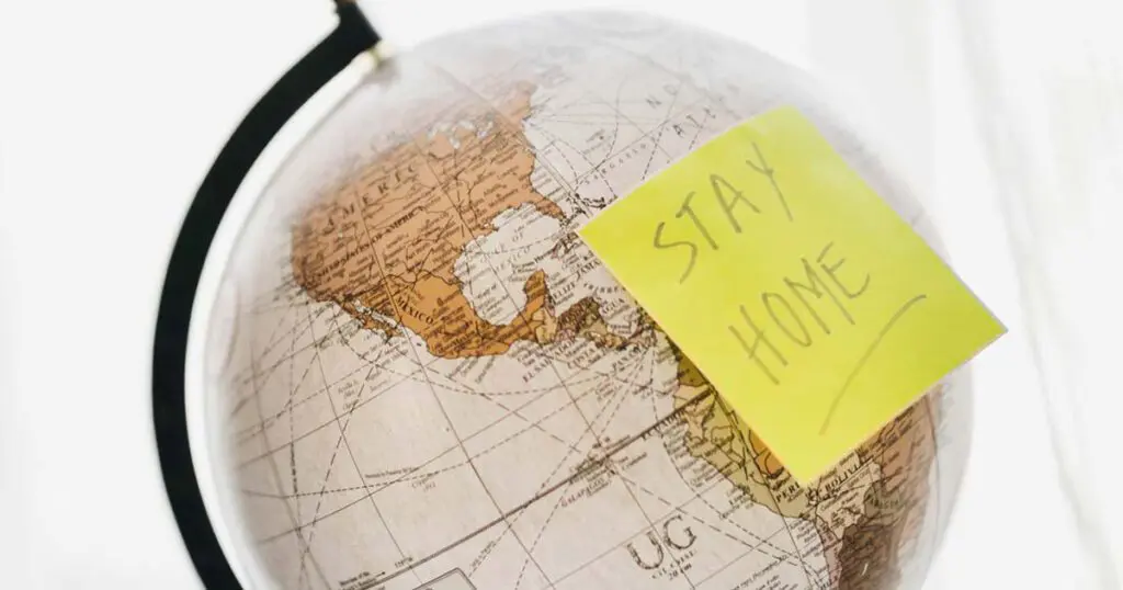 Globe with a yellow stickie "STAY HOME"