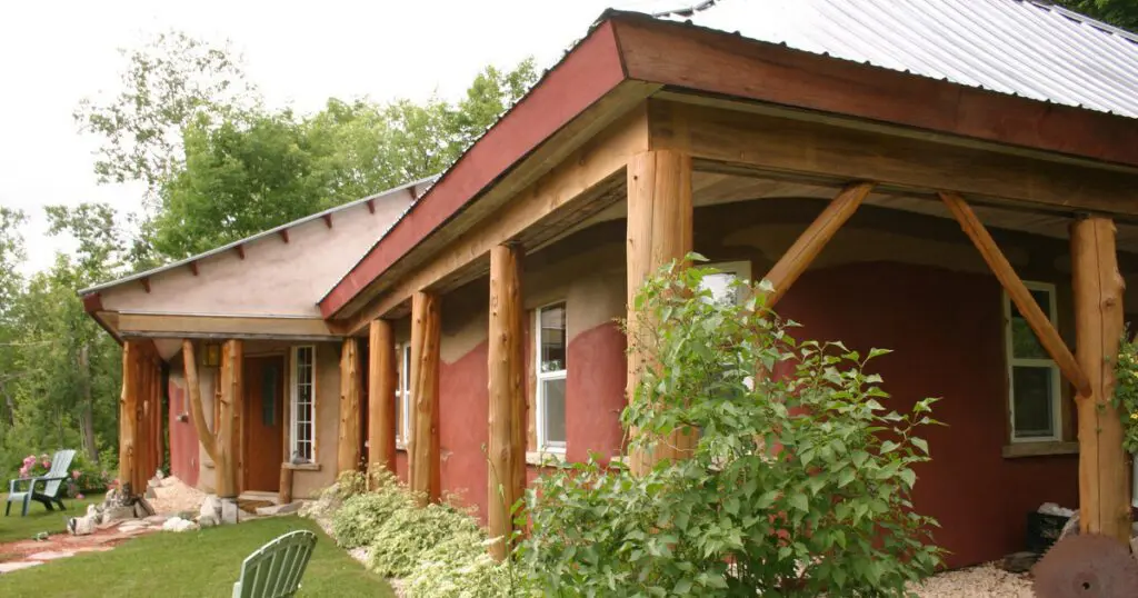 Wood and plaster home with wooden porch supports.