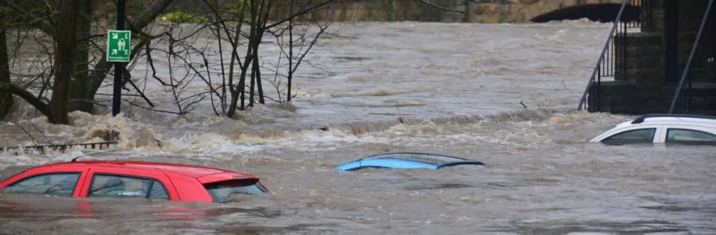 Three cars trapped in flood water up to their roofs.