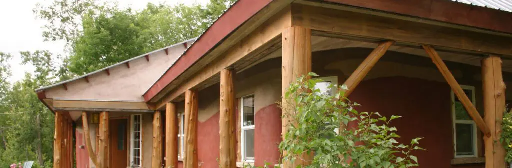 Wood and plaster home with wooden porch supports.