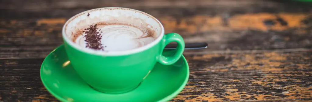 A delicious-looking cup of hot chocolate with foam and chocolate sprinkles.