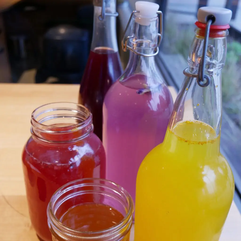 Assorted bottles of turmeric cardamom fizz on a table.