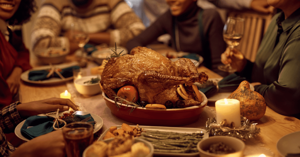 A family is hosting an eco-friendly gathering, delighting in a festive dinner with a roasted turkey centerpiece.