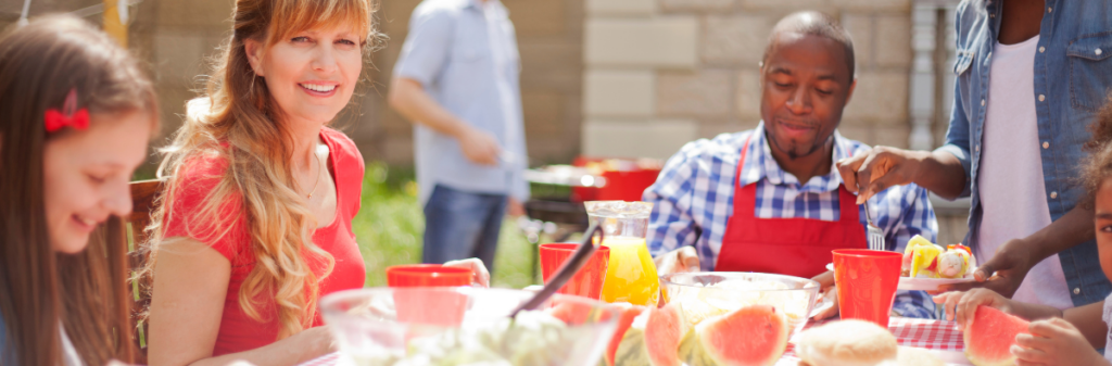 People enjoying modern communal living outdoors around a picnic table with red cups.