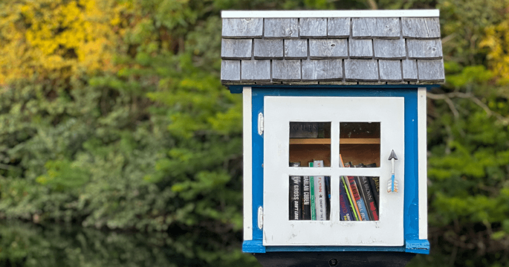 Simplified mini library, surrounded by lush green foliage.