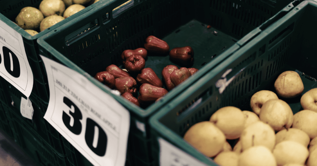 Fruits in green crates with price tags, promoting 2025 food security in North America markets.