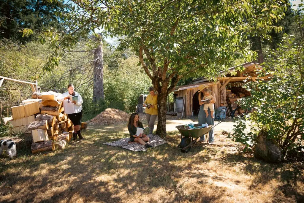 New Society Publishers, activist publisher staff enjoy a sunny, grassy yard near a rustic shed.
