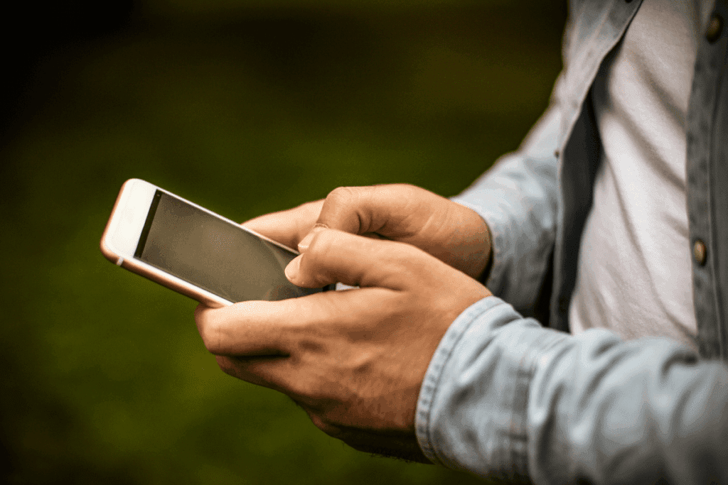 Close-up of person using a smartphone outdoors, reflecting on the 2.5 tonnes magic number.