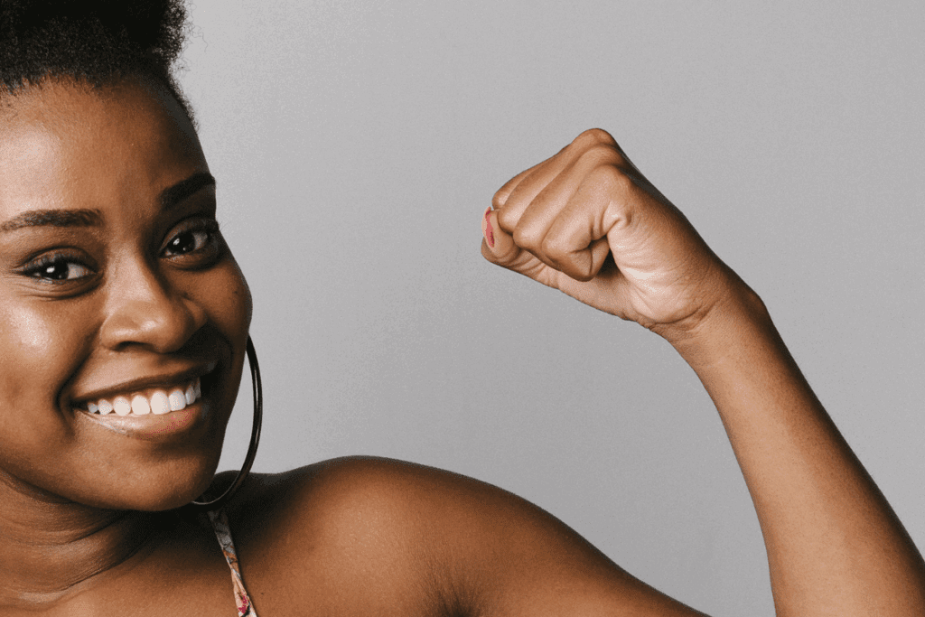 Smiling woman flexing her arm in a confident pose, ready to face a warming world.
