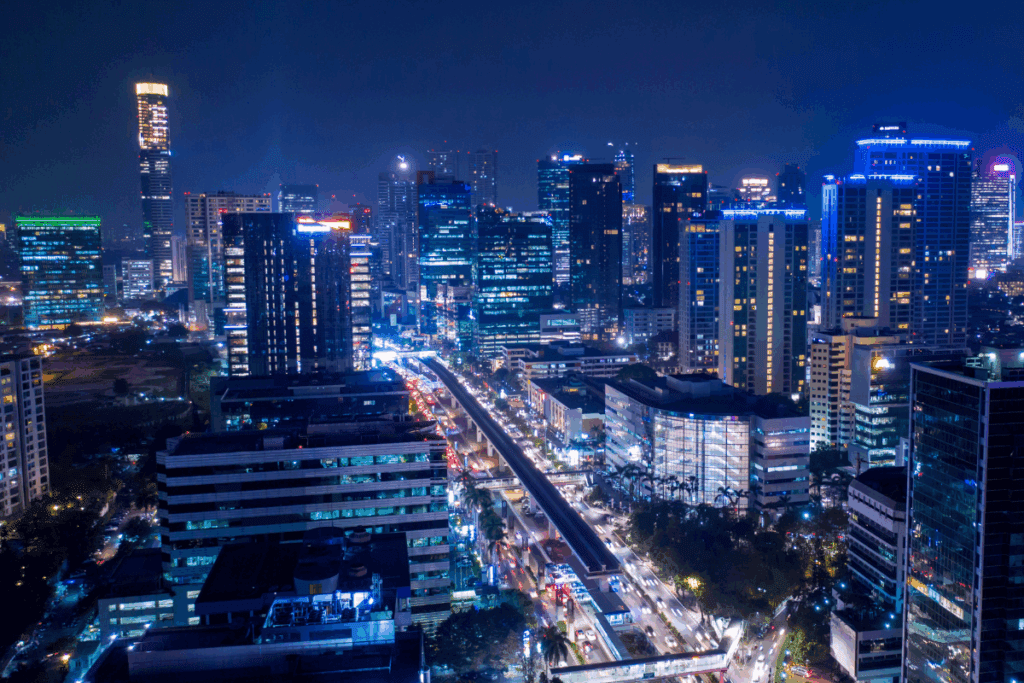 A city skyline at night highlighting energy-efficient buildings and bustling streets.