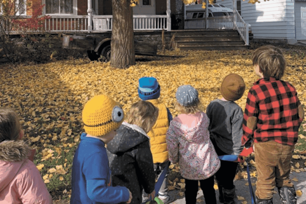Six children in autumn clothes gather by a tree, embodying timeless stewardship principles.