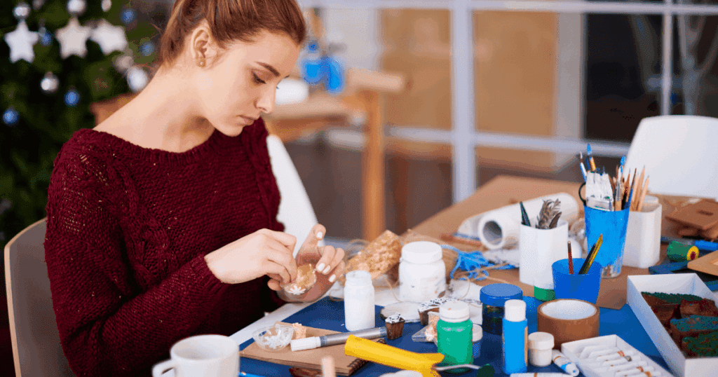 Older teenager crafting at a table, focused on her project—youth leadership in a distracted world.