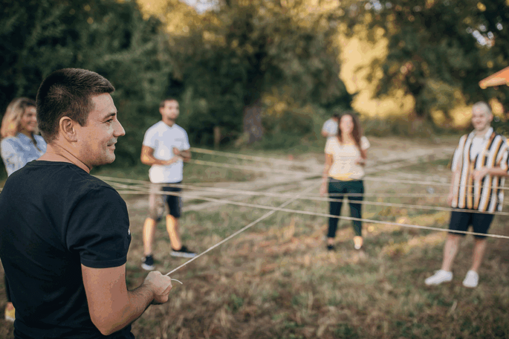Young leaders join in team building hands outdoors, helping youth thrive in a connected circle.