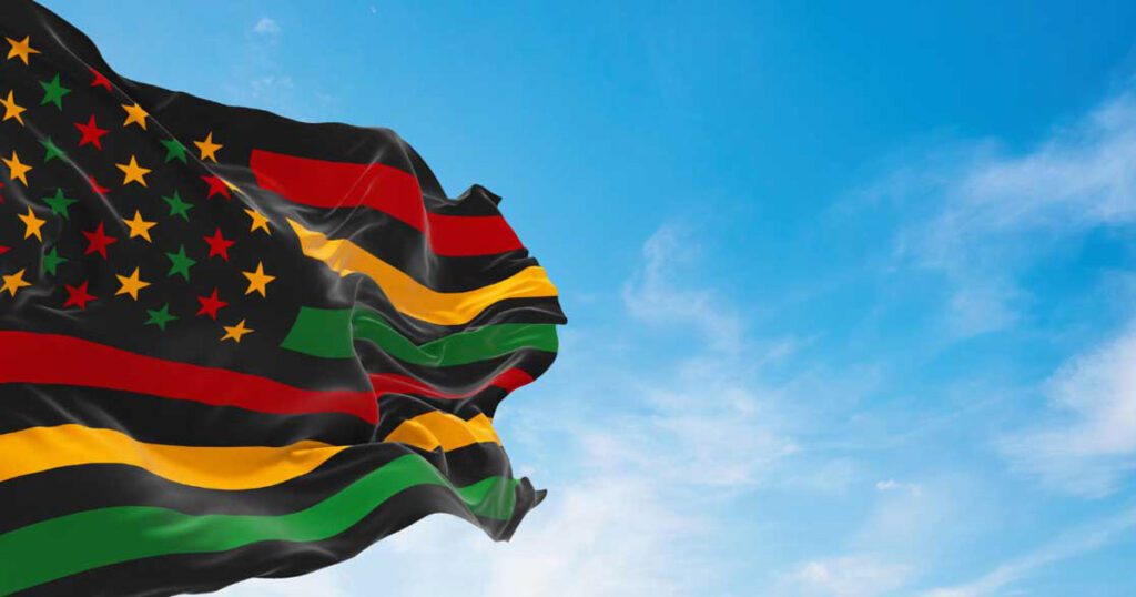 Juneteenth flag flying amongst a blue sky