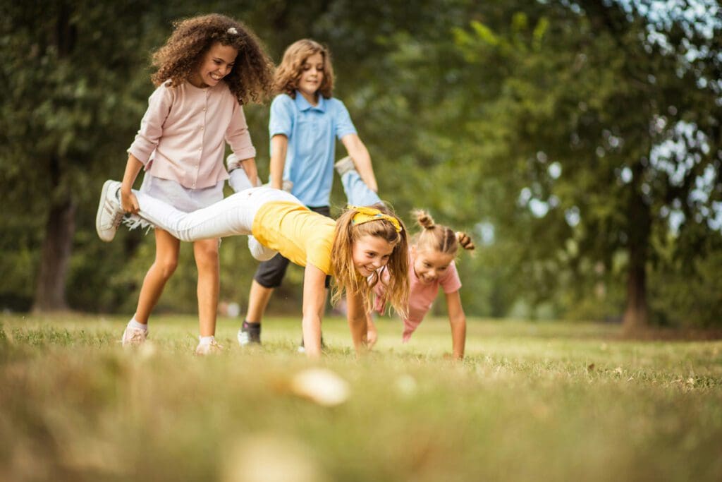 Two sets of kids playing "wheelbarrow"