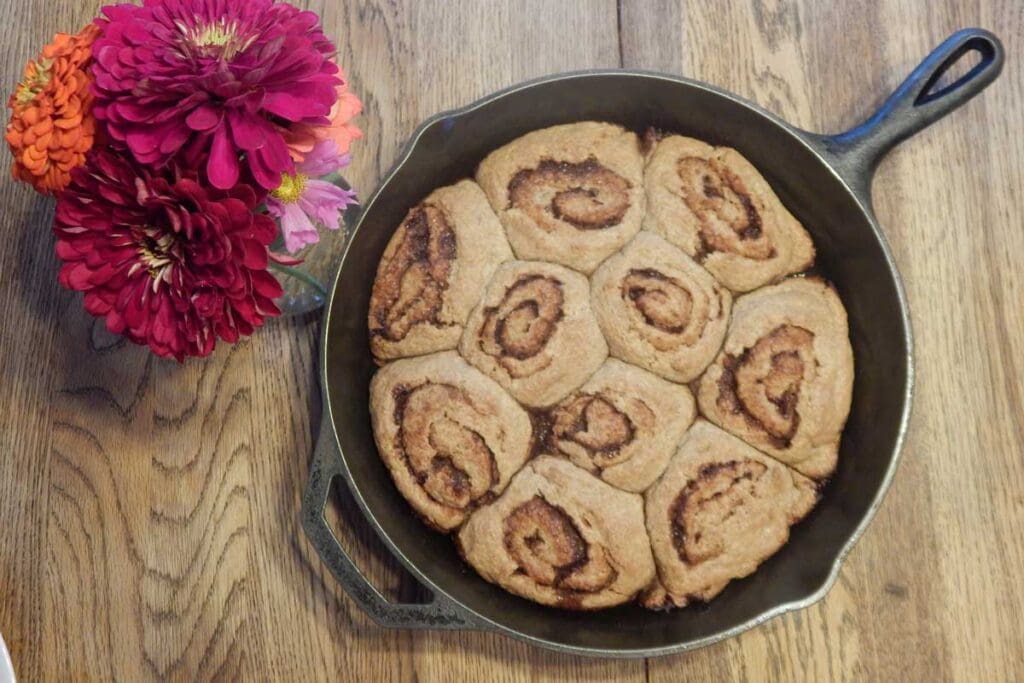 10 cooked cinnamon rolls in an iron skillet.