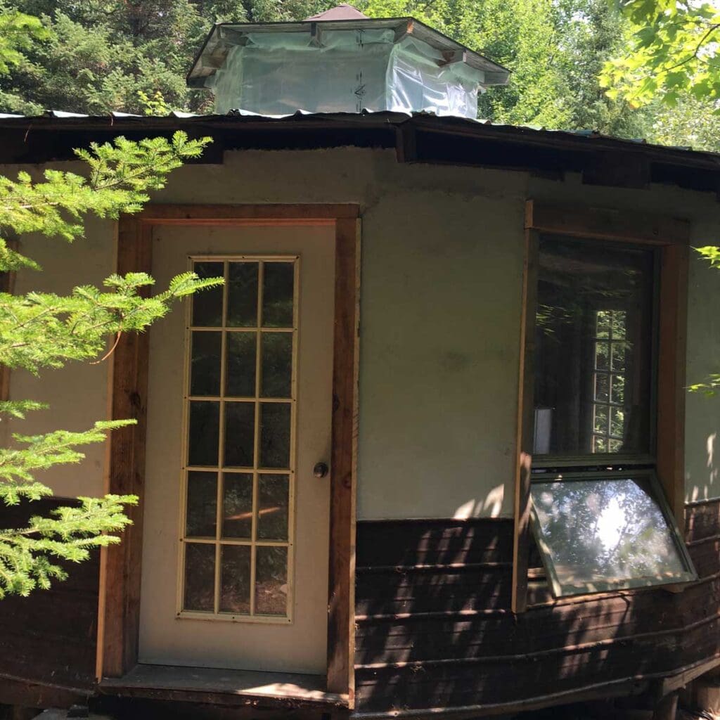 Entrance to round house with reclaimed windows & doors, and roofing.