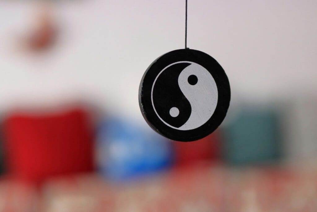 A black and white Yin Yang symbol hangs from a.string.