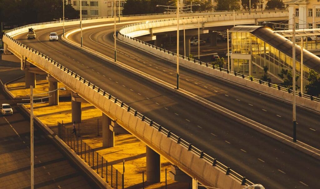 Curved highway overpass with two cars on the road.
