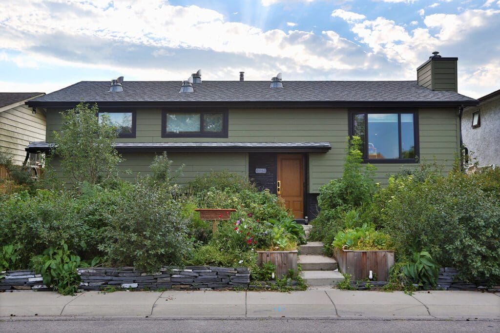 Simple split level home with plants and shrub decorating the front yard.