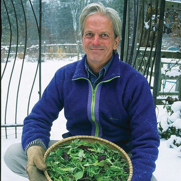 Farmer with a bowl of leafy greens outside in the middle of the winter.