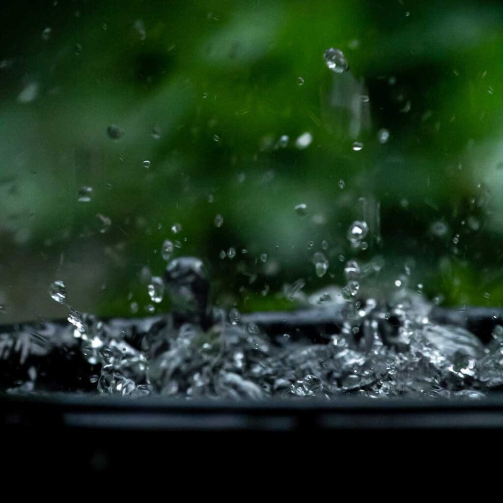 Rainwater falling in a bucket.