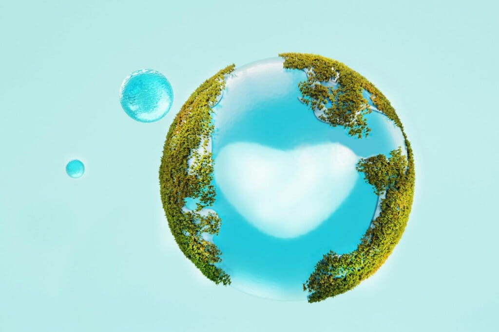 The world with green grass covering the land portion and a blue sky with a cloud in the shape of a heart representing the water.