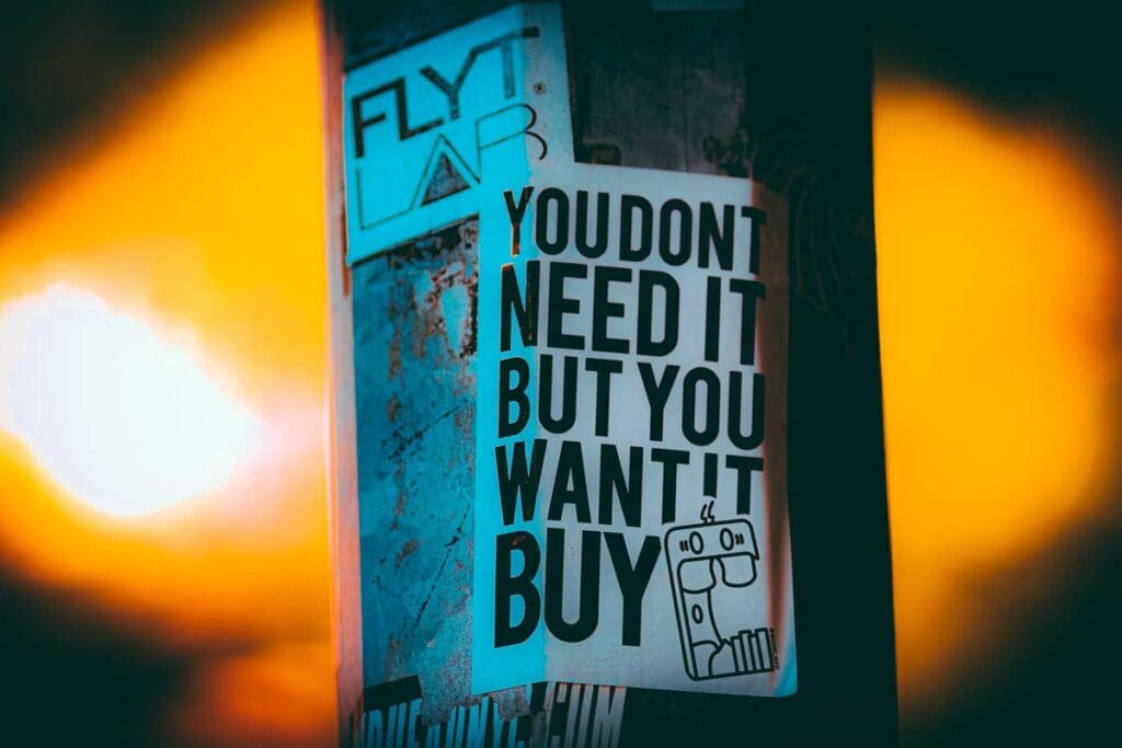 City lamppost at night with a flyer reading: You don't need it but you want it."