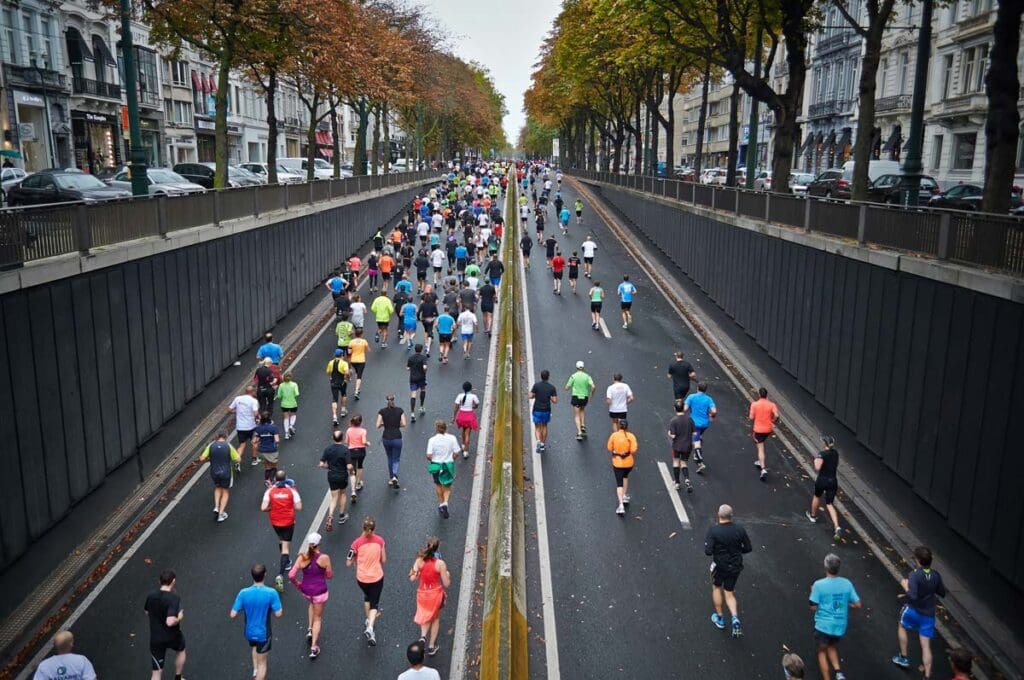 A large group of people run down both sides of a city street.