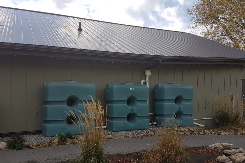 Home with a metal roof and 3 water tanks.