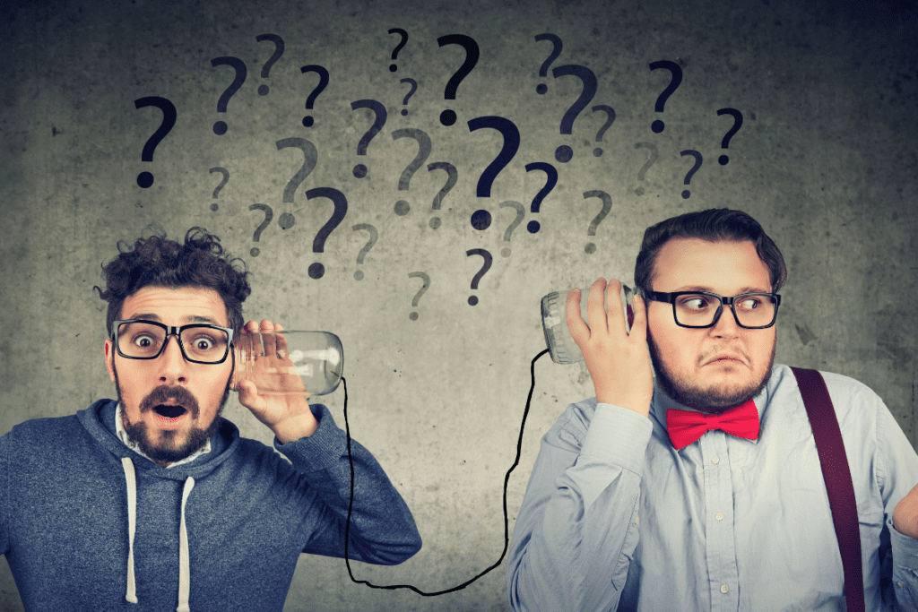 Two men hold glasses connected by string to their ears as question marks sit above their heads