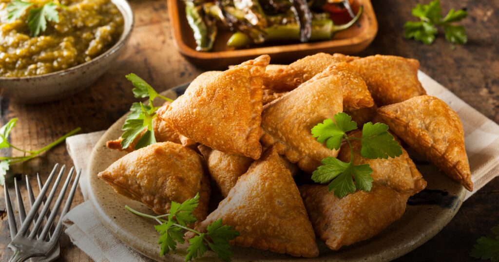 A beautifully cooked meal of samosas and extras on the table