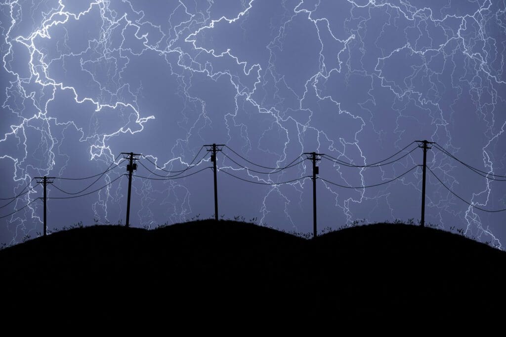 A dramatic night scene features silhouetted utility poles and power lines stretching across the skyline. In the background, an intense lightning storm with numerous jagged bolts lights up the dark, cloudy sky.