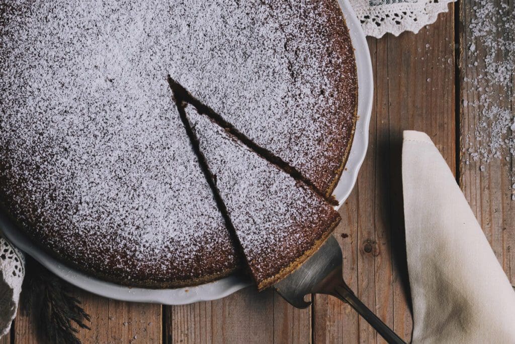 A portion of chocolate tart is cut from the whole.