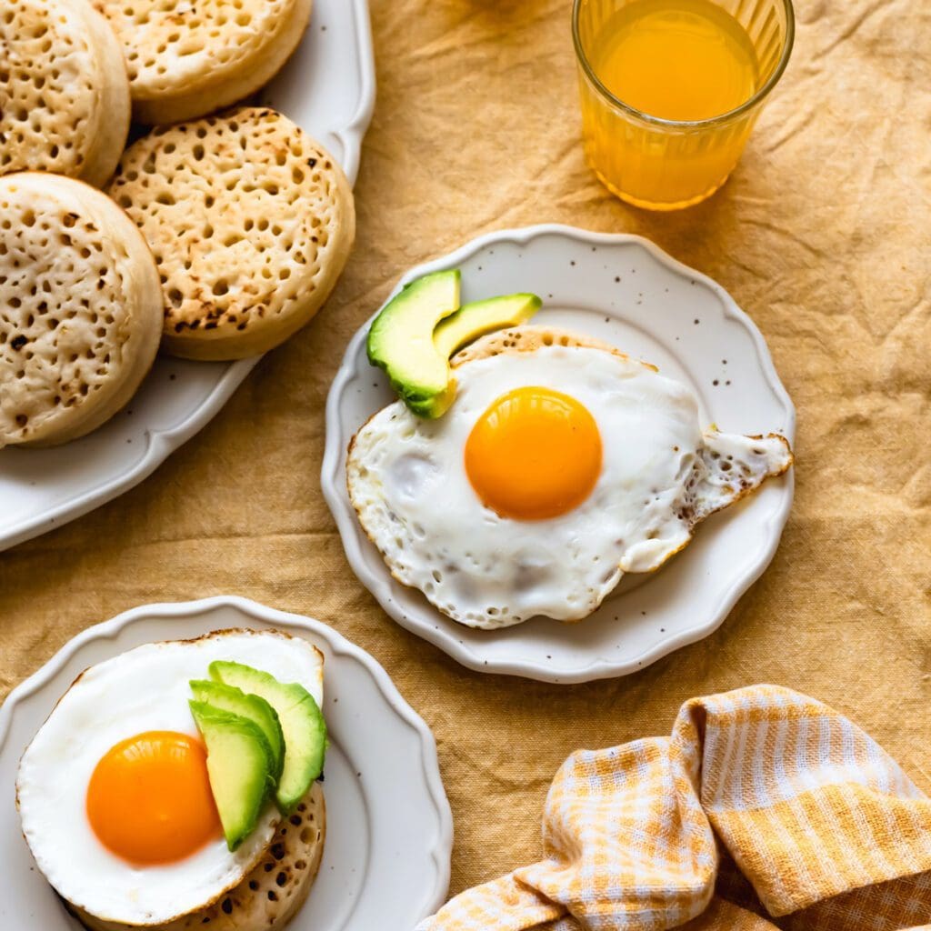 Sunny side up eggs and avocado on crumpets