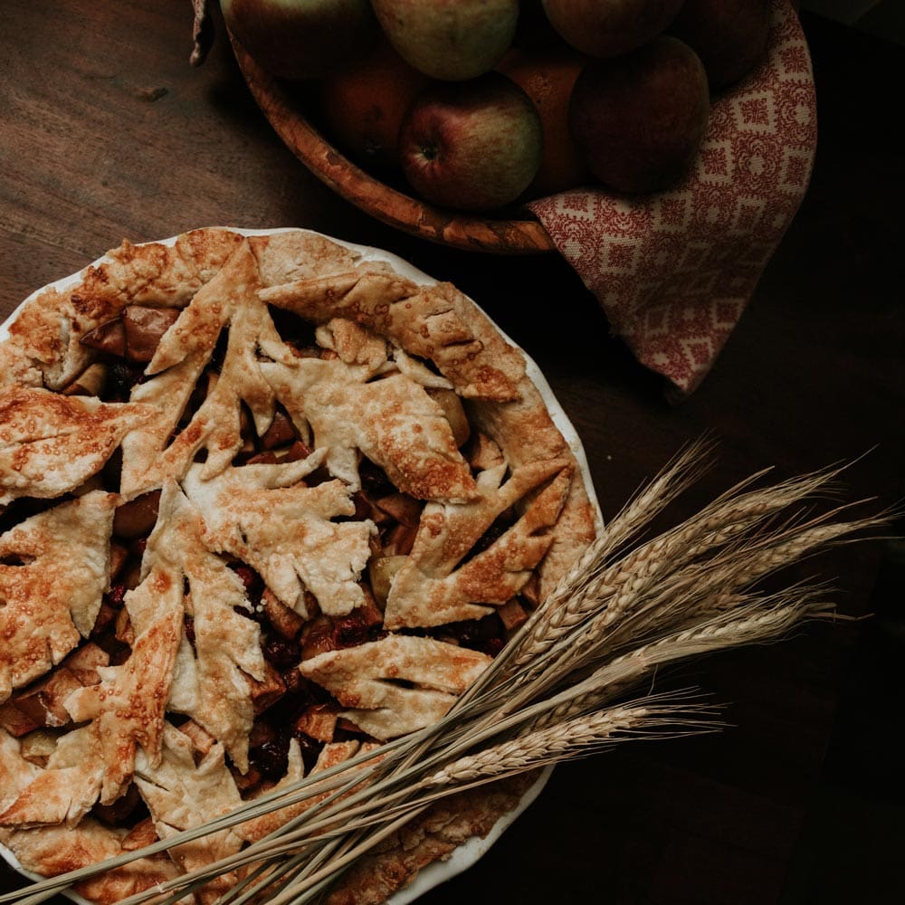 Freshly baked apple pie garnished with wheat.