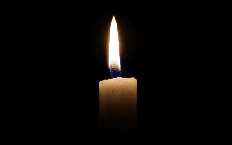 Lit candle in the dark.