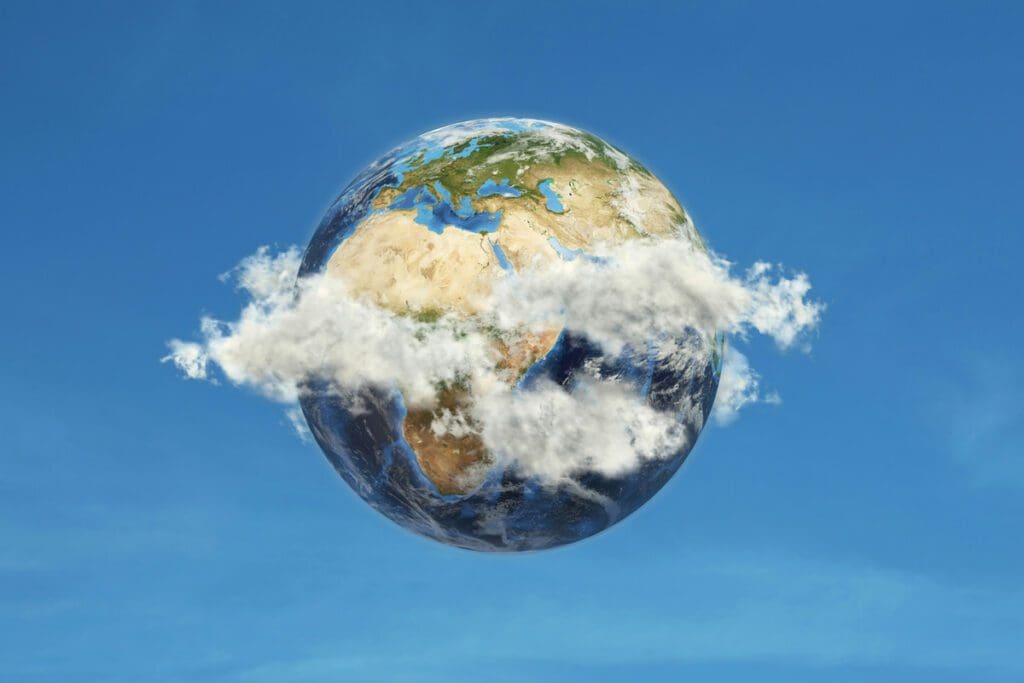 A mesmerizing view captured in "getty-images-Ae-KmW-hV0c-unsplash" depicts Earth suspended against a pristine blue sky, with soft white clouds gently veiling the continents of Africa, Europe, and Asia. The lush greens and rich browns of land and the profound blues of oceans peek through the cloud cover, offering a striking reminder of the natural beauty we must safeguard through environmental activism.