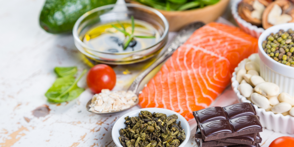 A vibrant array of healthy foods, including salmon, chocolate, beans, greens, and mushrooms.