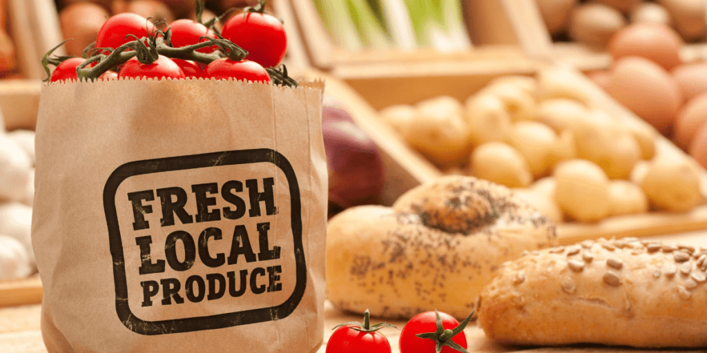 A bag labeled "Fresh Local Produce," with tomatoes, bread, and potatoes in the background, hints at an eco-friendly gathering.