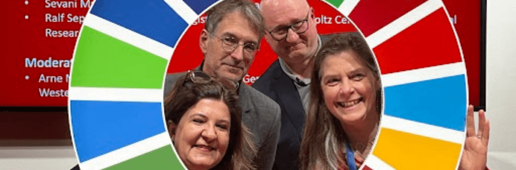 Four people smiling through a colorful circular frame with a red background, bringing to mind the vibrant atmosphere of publishers gathering for sustainability discussions in bustling Frankfurt.