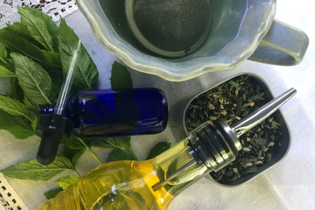 Handmade herbal leaves, oil, and dropper bottles are elegantly arranged on a lace tablecloth, evoking a sense of holiday charm.