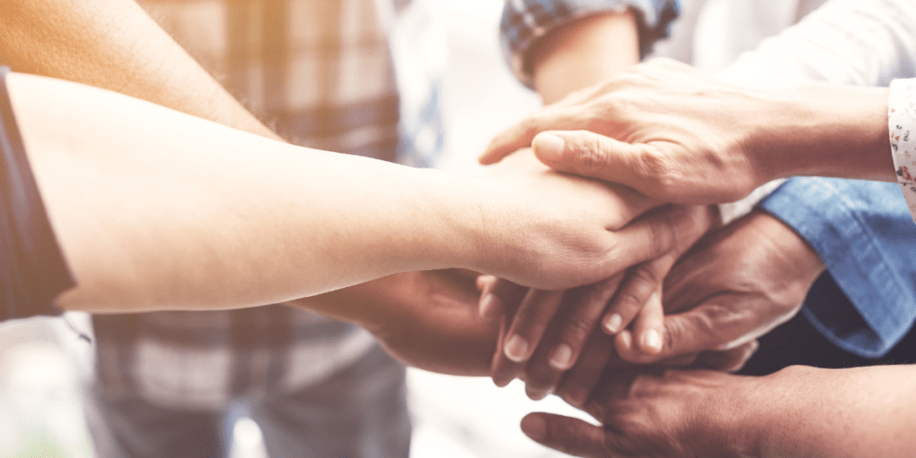 Close-up of diverse hands stacked in a show of teamwork and unity.