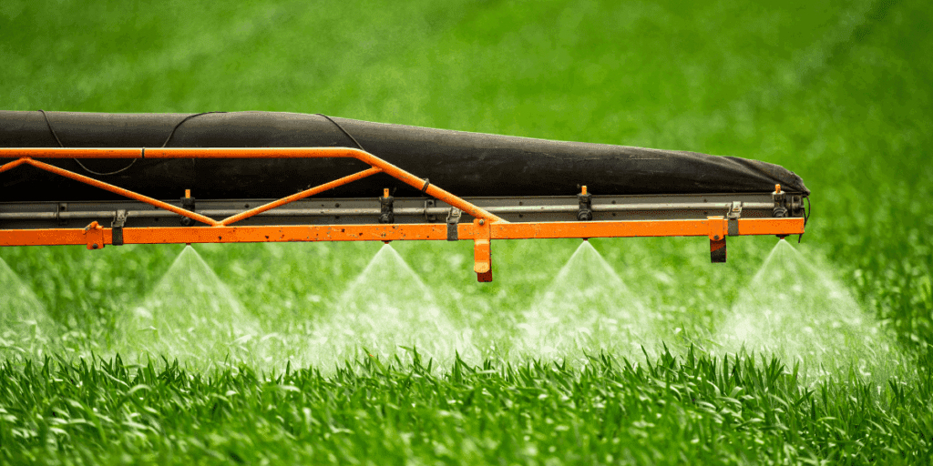 A crop sprayer releases mist, helping ensure year-round growth of good food in the green field.