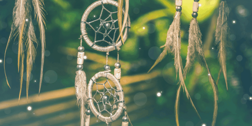 Indigenous cultural tradition of dreamcatchers with beads and feathers hanging, inviting an ethical perspective on the Indian Act.
