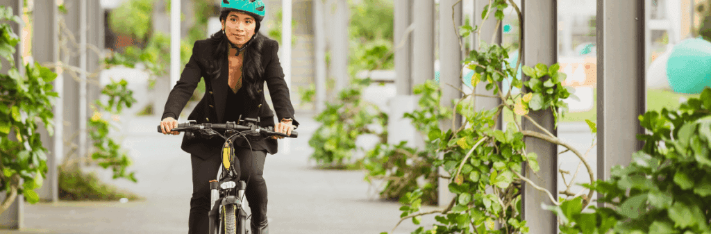 Person in a suit and blue helmet rides a bicycle, making lifestyle changes to save the planet.