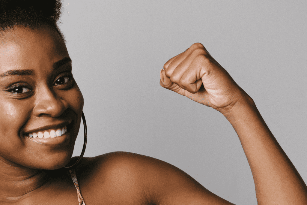 Smiling woman flexing her arm in a confident pose, ready to face a warming world.