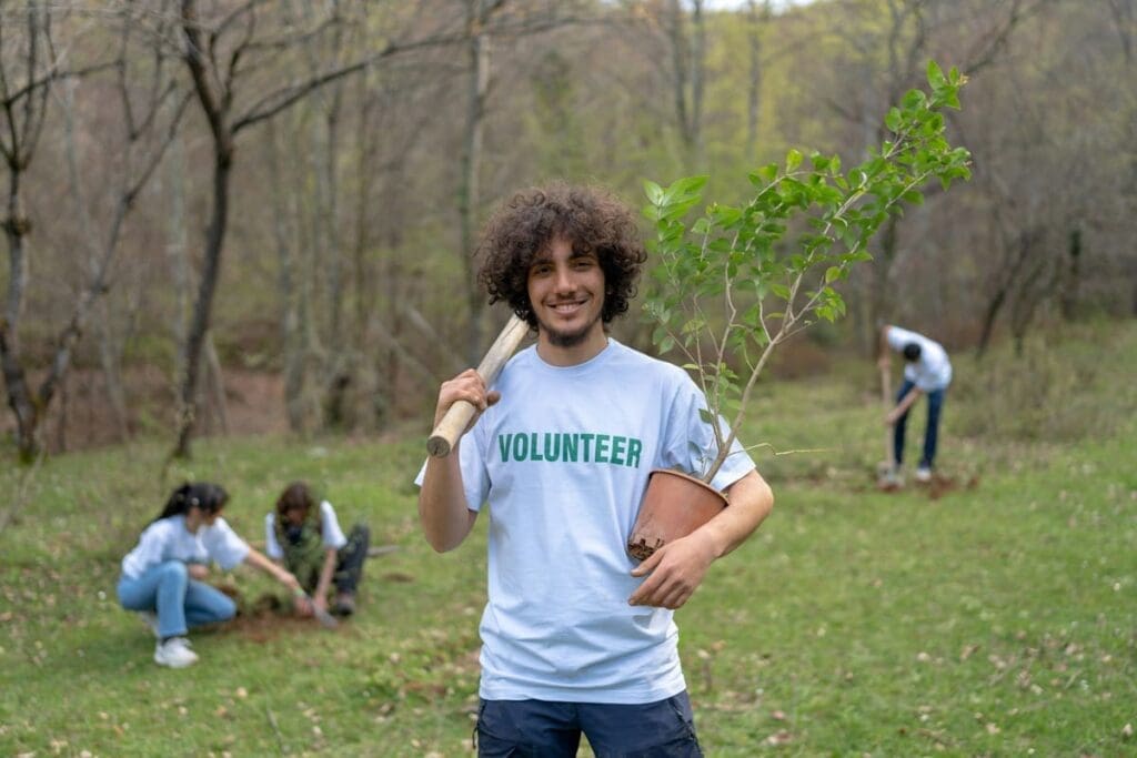 Smiling volunteer with kids planting trees, taking action on climate change for 2025.